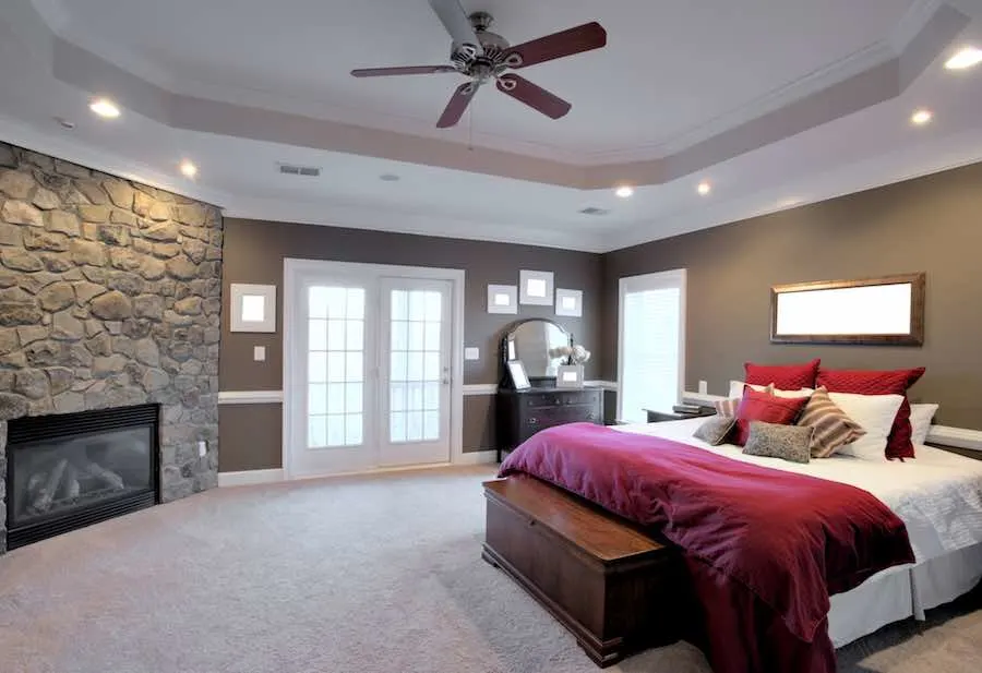 The Best Mold Killing Primer and Mold Resistant Paints 2 Interior of a large modern bedroom with a fireplace and ceiling fan. Horizontal format.