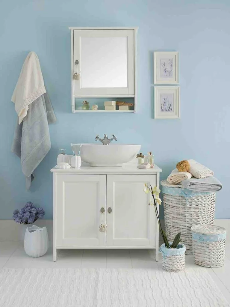 22 Inspiring Bathroom Paint Colors 10 A shabby chic bathroom vanity with purple and white flowers in vases, woven baskets, and hanging towels.