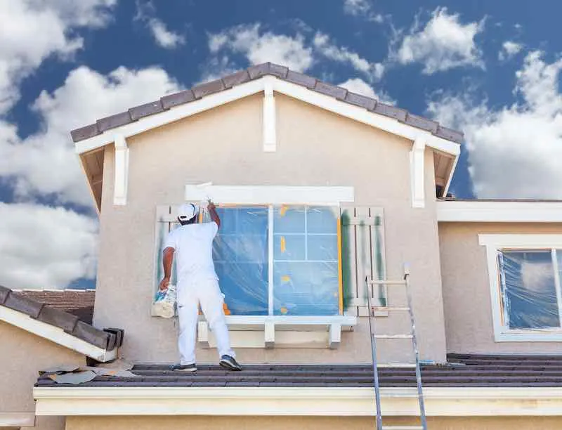 How Much Does It Cost To Paint a House? A Detailed Breakdown Of House Painting Costs 2 Painter painting a house.