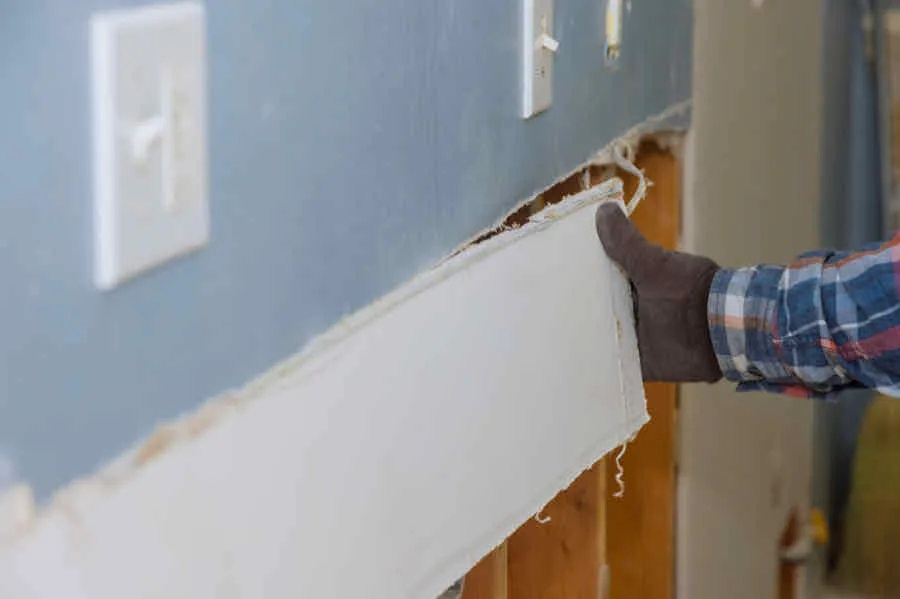 How to Remove Drywall Quickly, Easily, and Mess Free 1 removing a piece of drywall from a wall