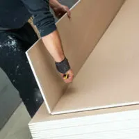 person scoring a drywall panel