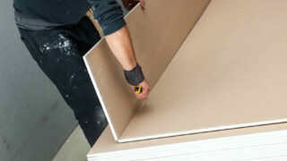 person scoring a drywall panel