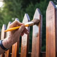 Applying the best exterior wood stain to a wooden fence