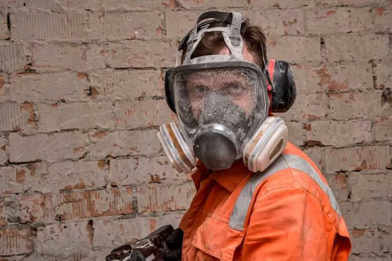 The Best Paint For Exterior Brick 2 Wearing a respirator for safety while painting brick