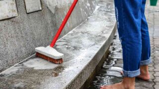 Woman using the best concrete cleaner to clean porch
