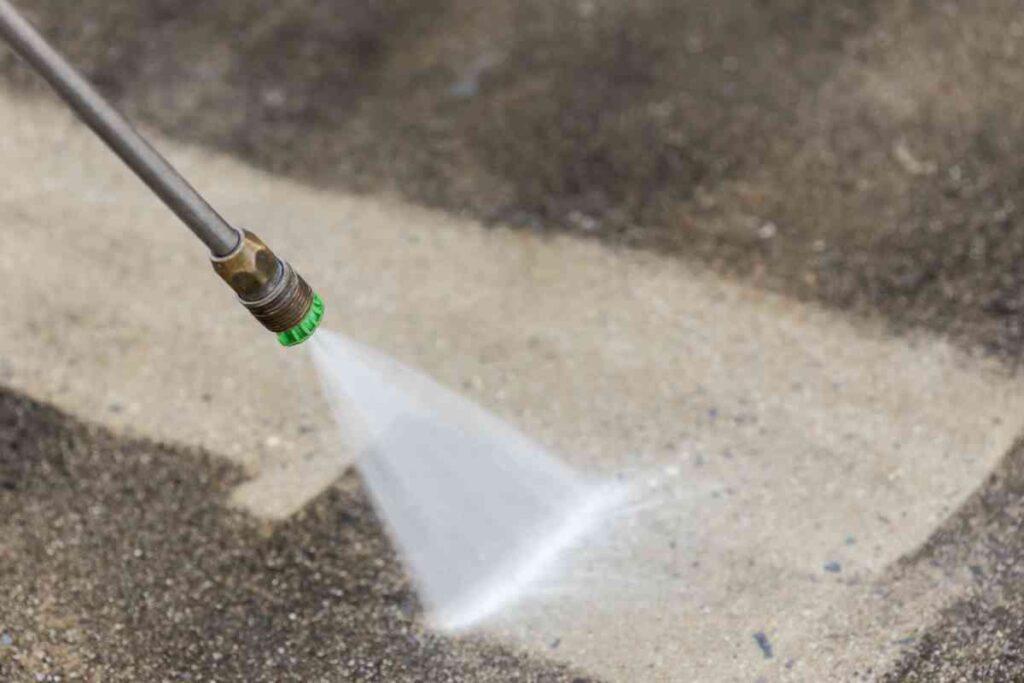 Using an electric pressure washer to clean concrete.