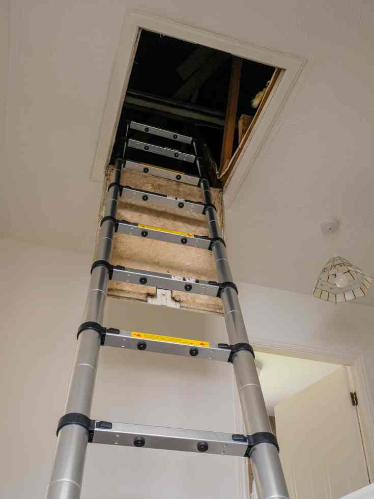 Telescoping ladder extended into an attic space