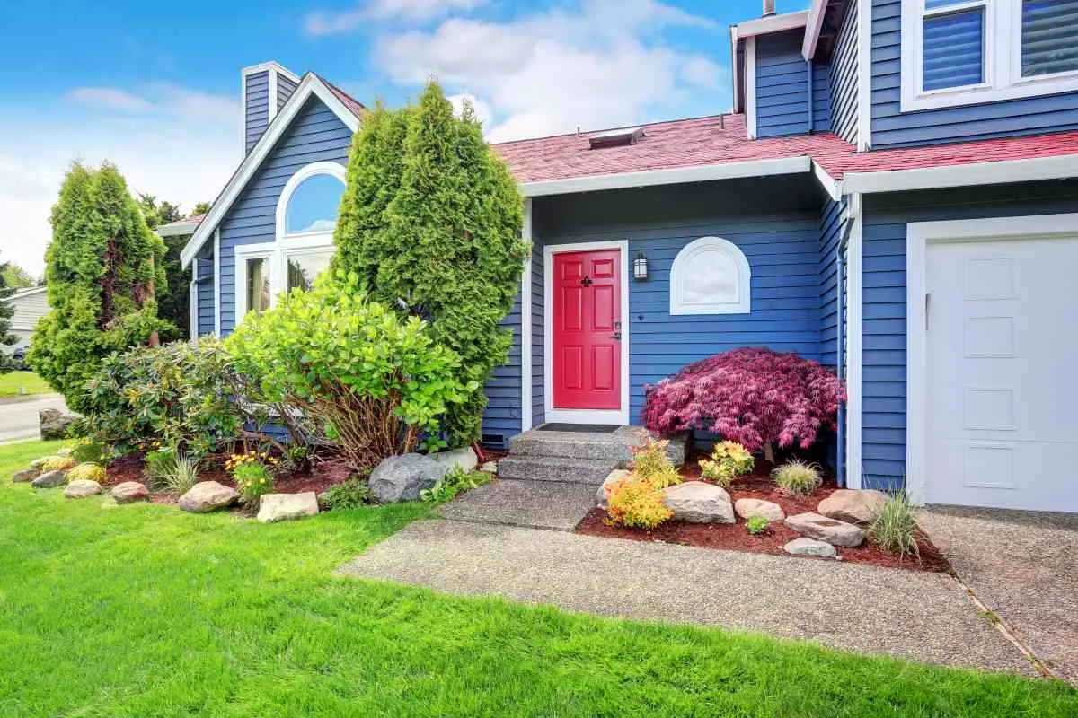 Exterior of house painted blue with red door showing sheen for exterior paint