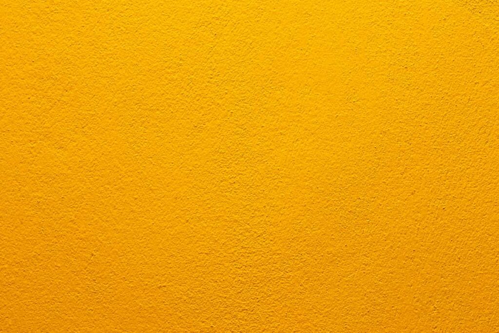 A concrete wall painted sunflower yellow.