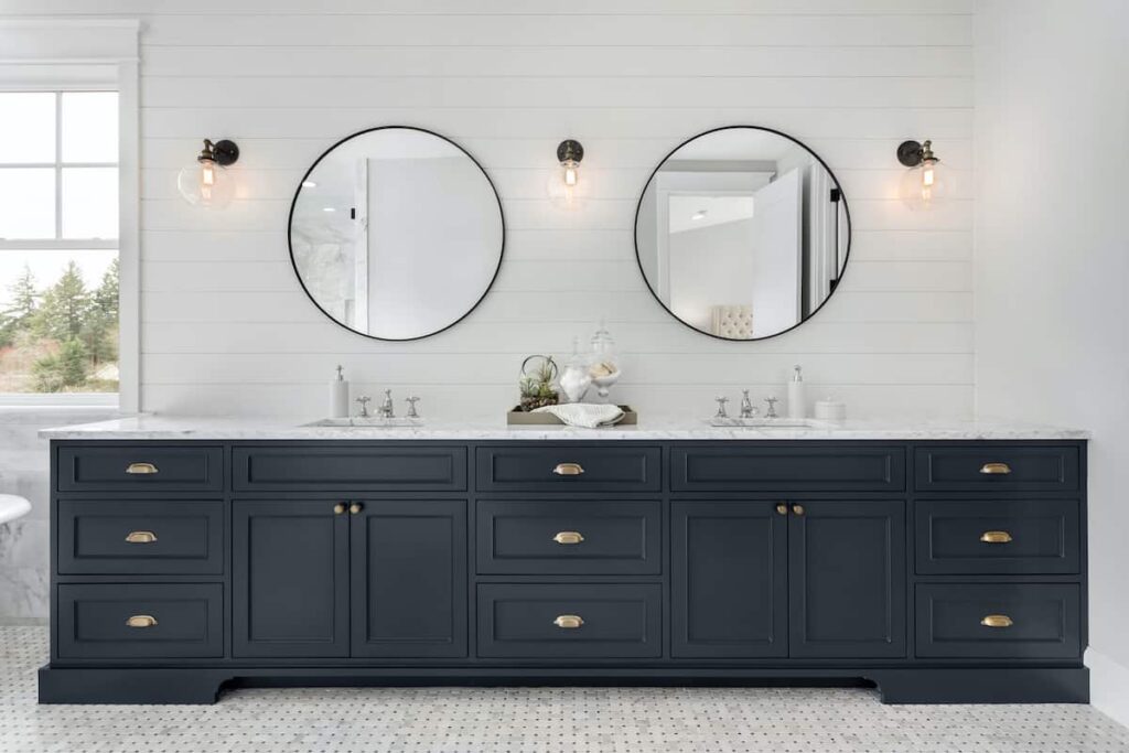 Bathroom vanity cabinets painted dark blue. Be sure to use the best paint for bathroom cabinets.