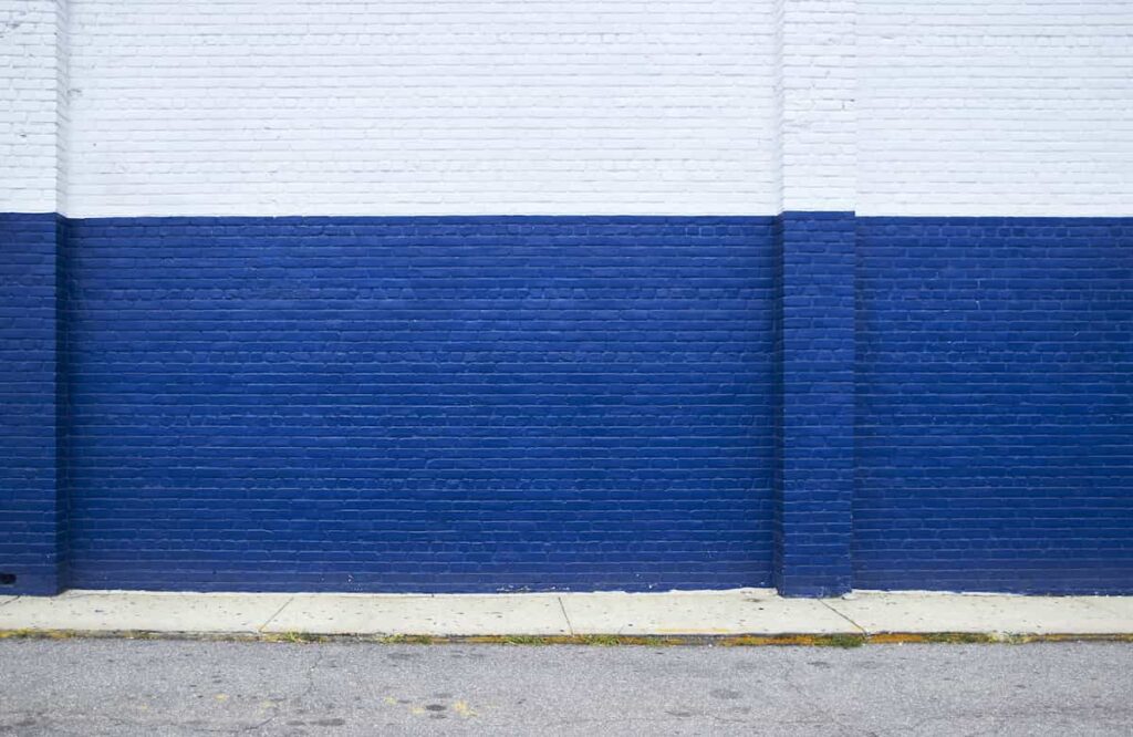 A concrete brick wall painted white and bright blue.
