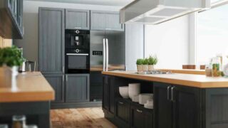 Gray cabinets with wood countertops topped with plants and accessories