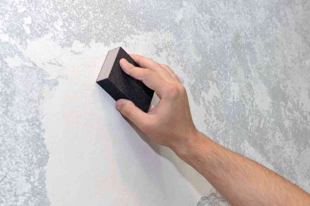Using a sanding sponge to wet-sand drywall repair