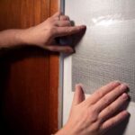 A man's hands showing how to repair holes in drywall