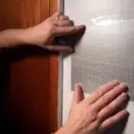 A man's hands showing how to repair holes in drywall
