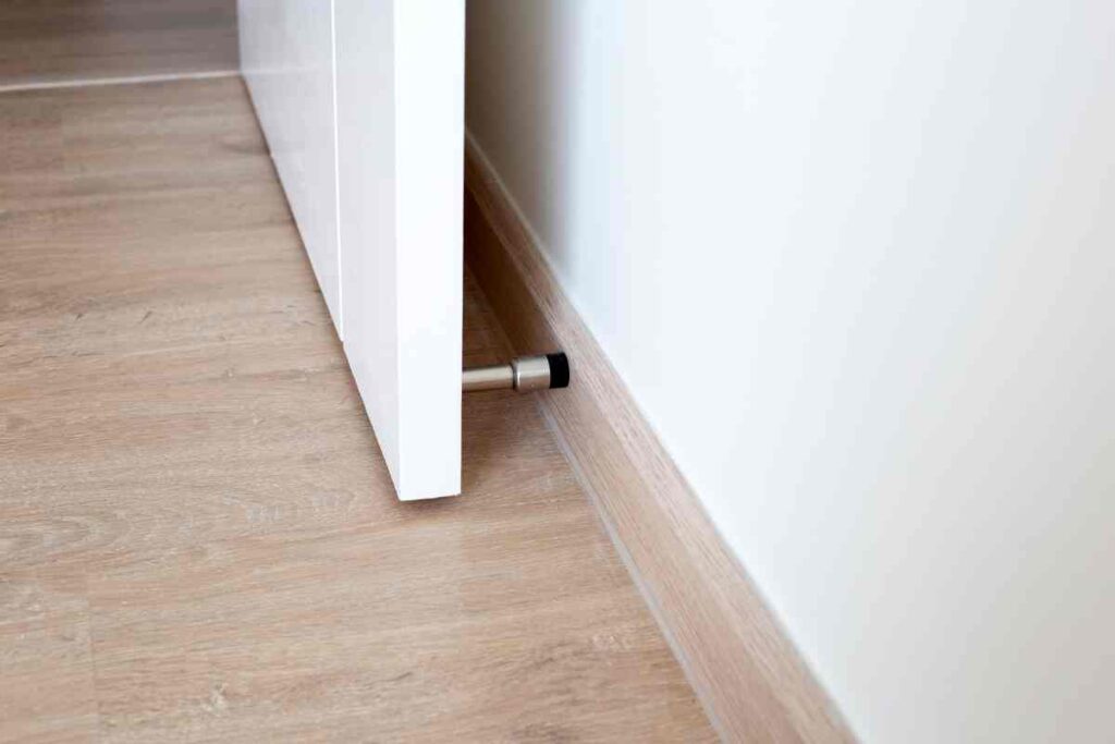 Using a door stopper to prevent damage to drywall