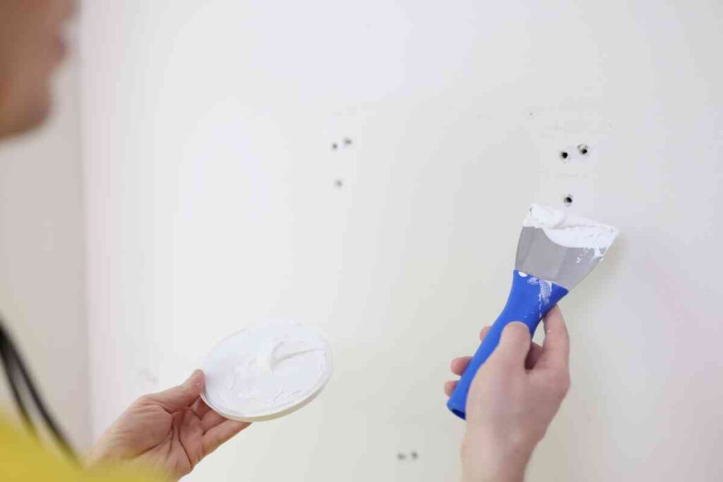 Using drywall spackle to repair holes left by drywall anchors