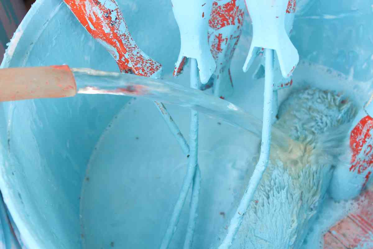 Paint rollers in a bucket of water before using the best paint roller cleaner to clean them
