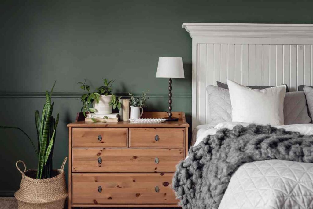 White bed with grey and natural wood accents.  A green wall for bedroom paint ideas