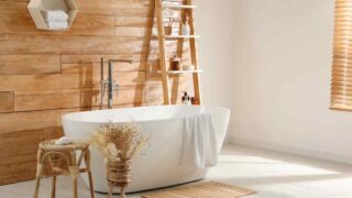Freestanding tub with plants and a ladder for shelving. DIY bathroom ideas