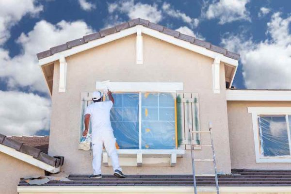 Professional House Painter Painting the Trim And Shutters of A Home.